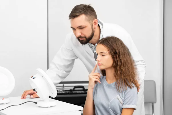 Oculist examines teenage girl in clinic — ストック写真