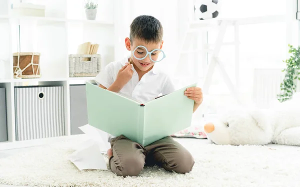 Bonito menino lendo livro agradável — Fotografia de Stock