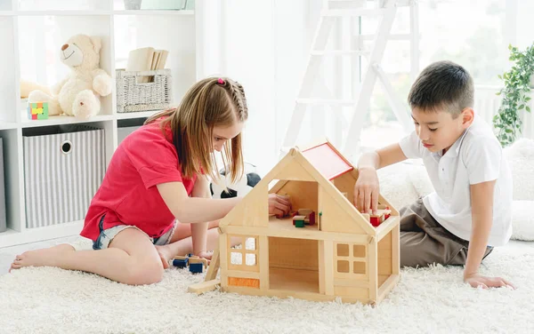 Симпатичные мальчик и девочка играют в помещении — стоковое фото