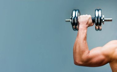 Gri arka plandaki kaslı adam