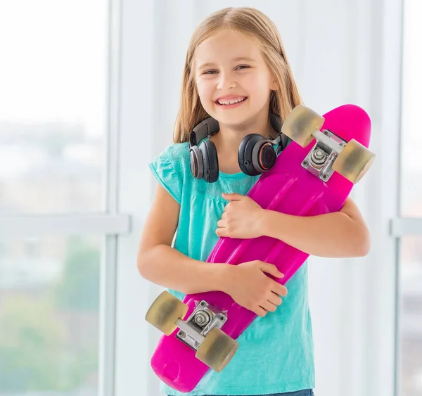 Smiling little girl with penny board — Stock Photo, Image