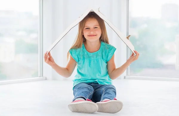 Kid girl put cardboard on her head — Stock Photo, Image