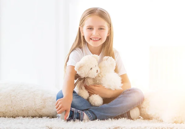 Alegre niña abrazando juguetes —  Fotos de Stock