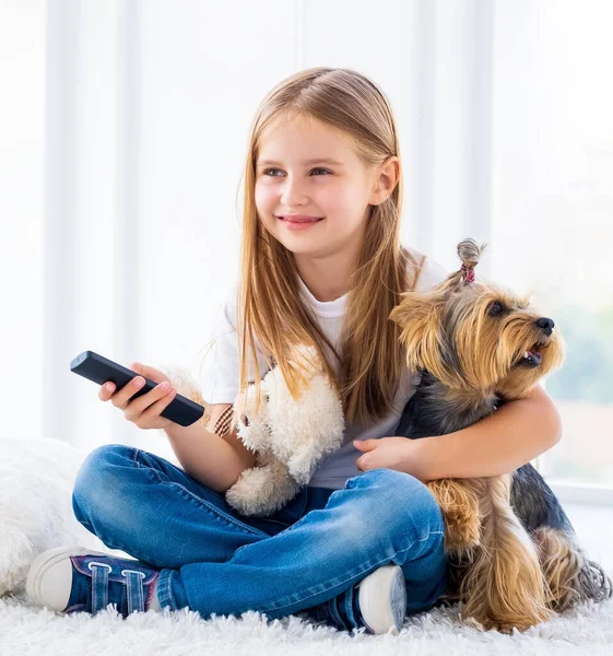 Dziewczyna i jej pies zmieniają kanały — Zdjęcie stockowe