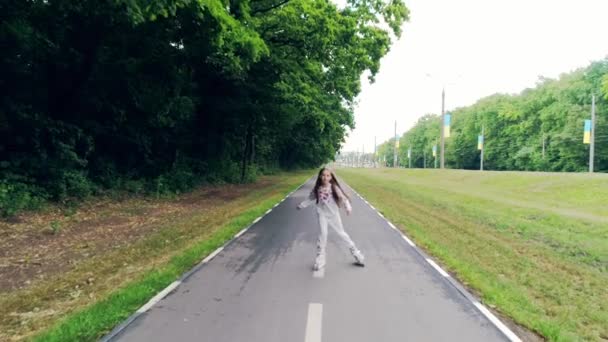 Klein meisje schaatsen met inline schaatsen — Stockvideo