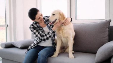 Mutlu kadın sevimli köpeği okşuyor.