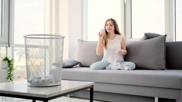 Дівчина кидає паперові кульки в кошик — стокове відео