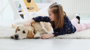 Sevimli küçük kız, sevimli köpeği avuçluyor.