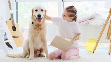 Şirin köpekli küçük kız kitap okuyor.