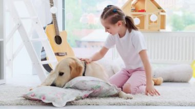 Mutlu küçük kız sevimli köpeğe sarılıyor.