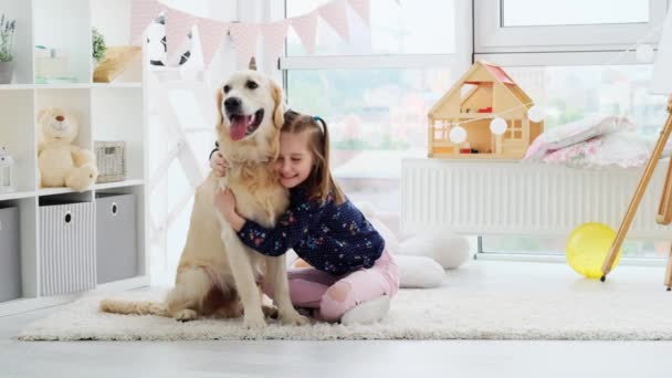 Happy little girl cuddling cute dog — Stock Video