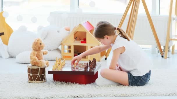 Kislány sakkozik Teddy-vel. — Stock videók