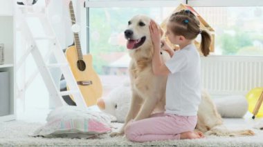 Mutlu küçük kız sevimli köpeğe sarılıyor.