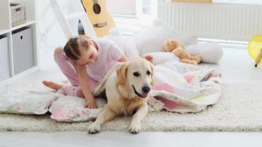 Mutlu küçük kız sevimli köpeğe sarılıyor.