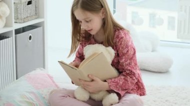Küçük kız kitap okuyor.