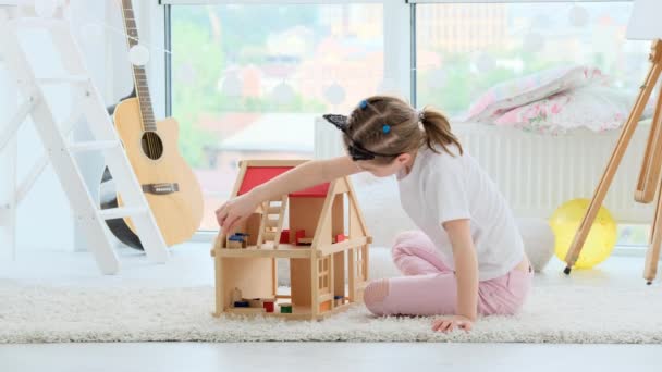 Niña jugando con casa de muñecas — Vídeo de stock