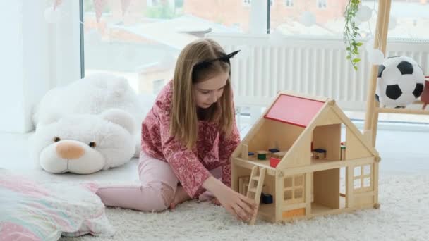 Niña jugando con casa de madera — Vídeos de Stock