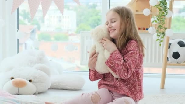 Petite fille étreignant ours en peluche blanc — Video