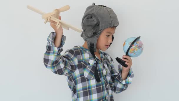 Маленький хлопчик грає з глобусом і літаком — стокове відео