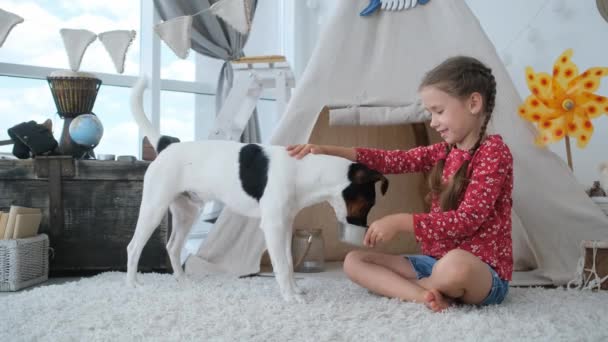 Klein meisje palmen hond tijdens het eten — Stockvideo