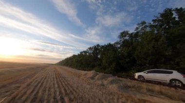 Araba hasat tarlasından geçiyor.