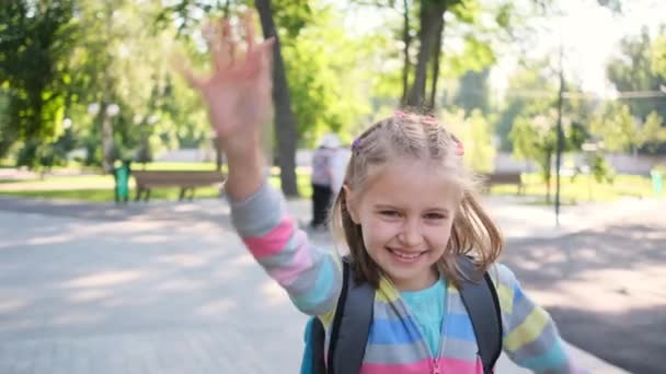Kleines Mädchen geht durch Park zur Schule — Stockvideo
