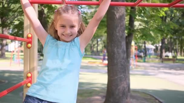 Маленька дівчинка на дитячому майданчику в парку — стокове відео