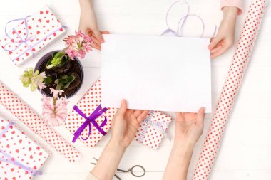 Elinde boş bir kağıt parçası var.