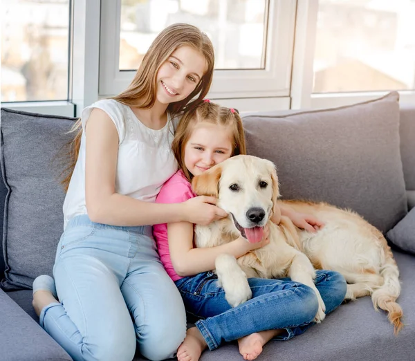 Sorrindo meninas abraçando lindo cão — Fotografia de Stock