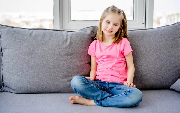 Cute little girl siedzi na kanapie — Zdjęcie stockowe