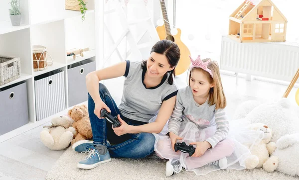 Dívka hraje videohru s matkou — Stock fotografie