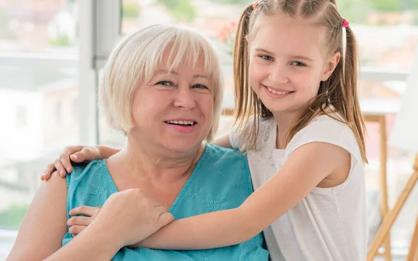 Gelukkig grootmoeder knuffelen met weinig kleindochter — Stockfoto