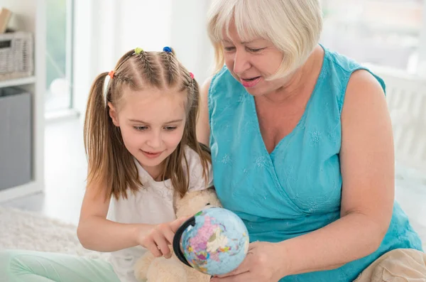Abuela y nieta examinando globo — Foto de Stock