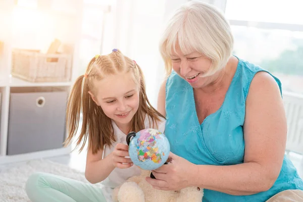 Glückliche Oma zeigt Enkelin Globus — Stockfoto