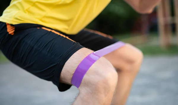 Man training knees using resistance band — Stock Photo, Image