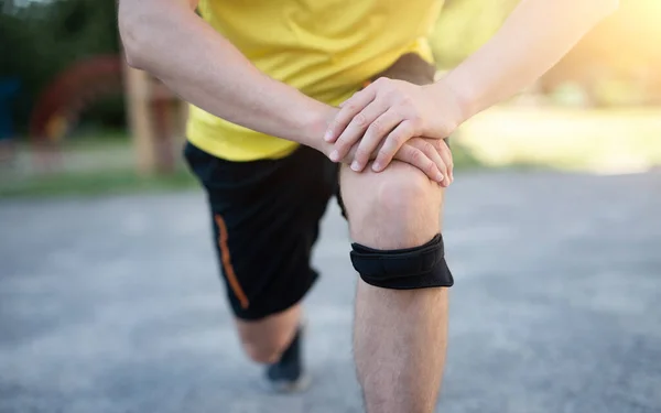 Mann trainiert mit schützendem Knieverband — Stockfoto