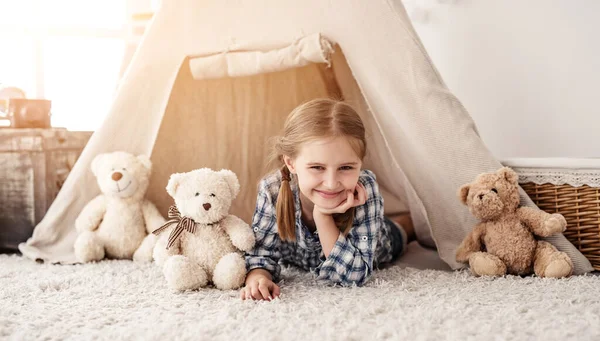 Sorrindo menina deitada em wigwam — Fotografia de Stock