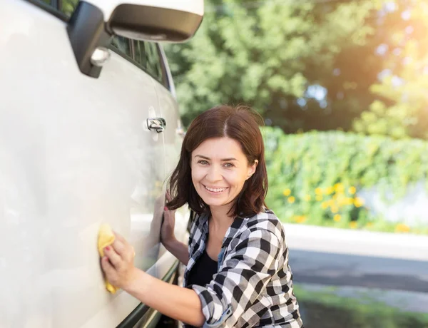 Woman with rag next to car — Stock Photo, Image