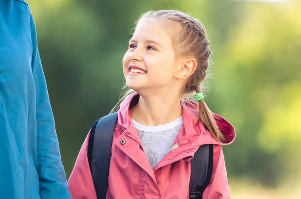 Skolflicka tittar upp på mamma — Stockfoto