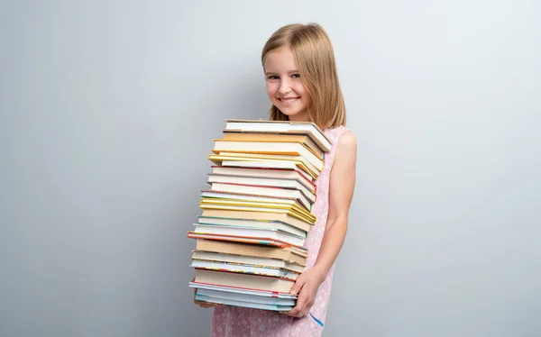Шкільна дівчина тримає стек книг — стокове фото