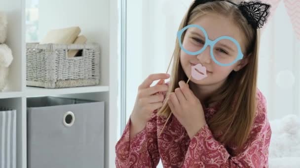 Маленькая девочка играет в бумажные очки — стоковое видео