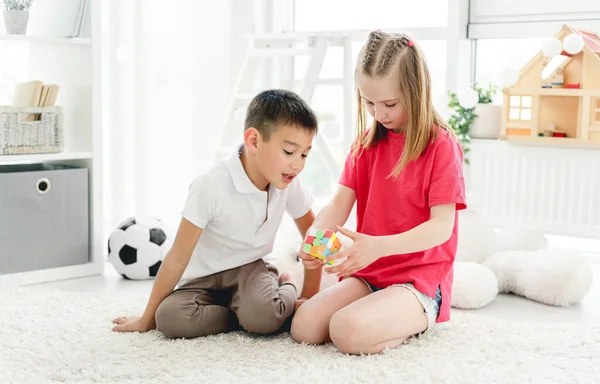 Rubiks küpüyle oynayan sevimli çocuklar.