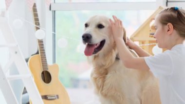 Mutlu küçük kız sevimli köpeğe sarılıyor.