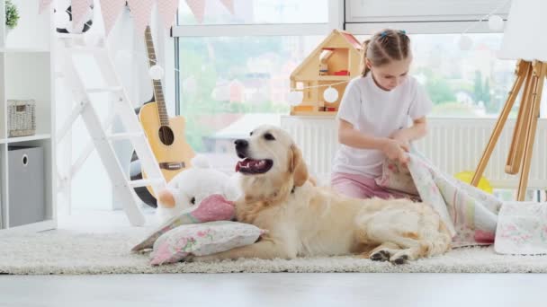 En pen jente som legger et teppe over hunden. – stockvideo
