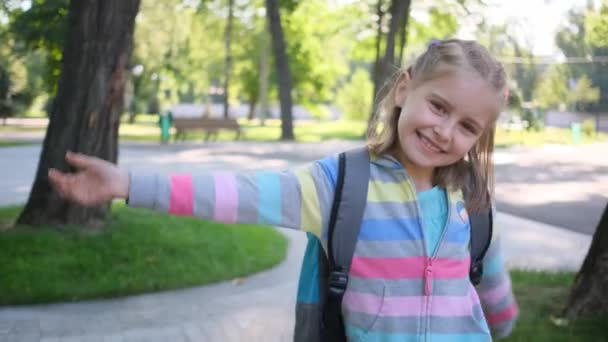 Маленька дівчинка ходить в парку після школи — стокове відео