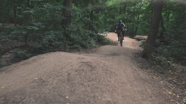 Ciclista montar en bicicleta en carretera forestal — Vídeo de stock