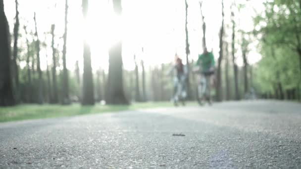 Couple faire du vélo le long du trottoir — Video
