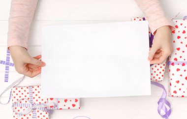 Elinde boş bir kağıt parçası var.