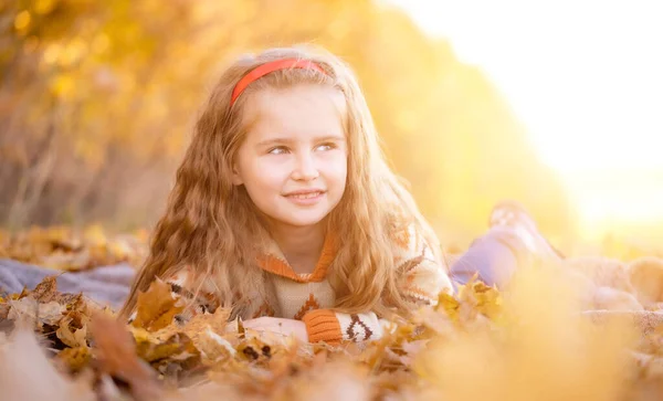 Kind ligt op herfstbladeren — Stockfoto