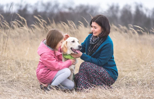 Mädchen und Frau streicheln Hund — Stockfoto